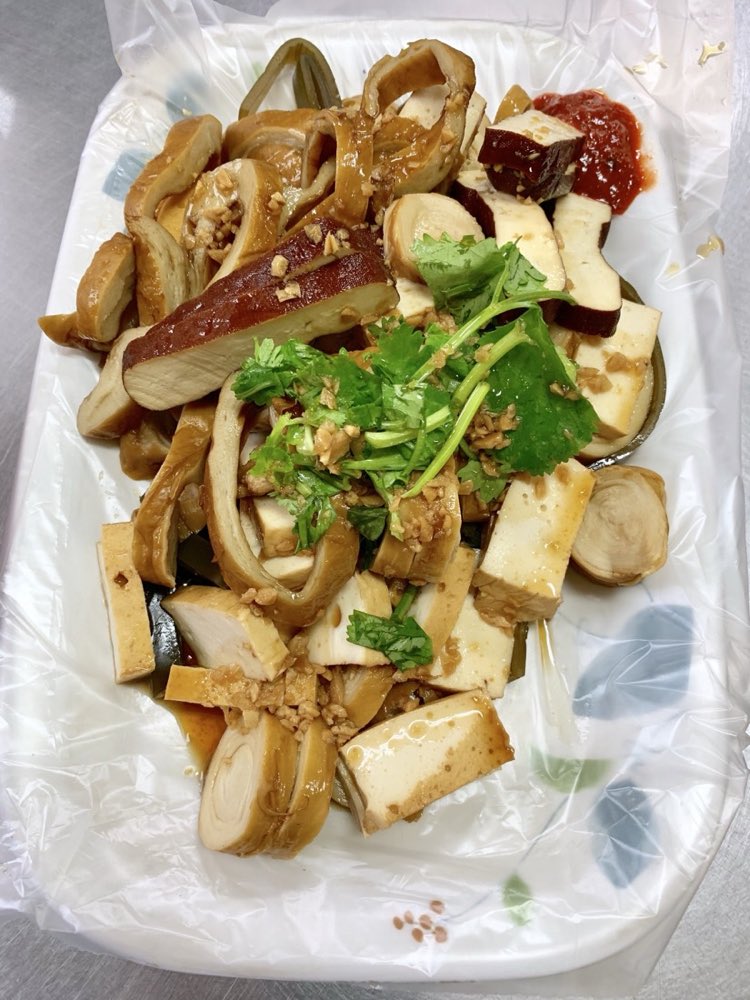 一盘切片的大溪卤豆干，拌上香菜与蒜，当零嘴吃